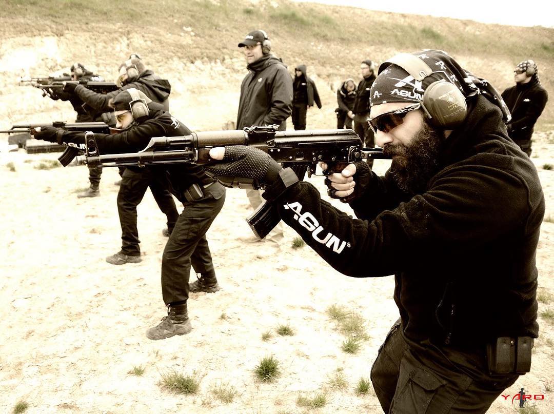 Eğitmenler gözlemlerken açık sahada tüfekle atış yapan kursiyer hattı