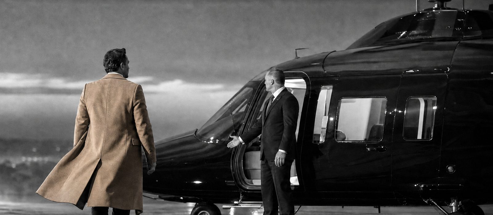 Passenger walking to a private helicopter as a protection officer shows the way to the cabin door