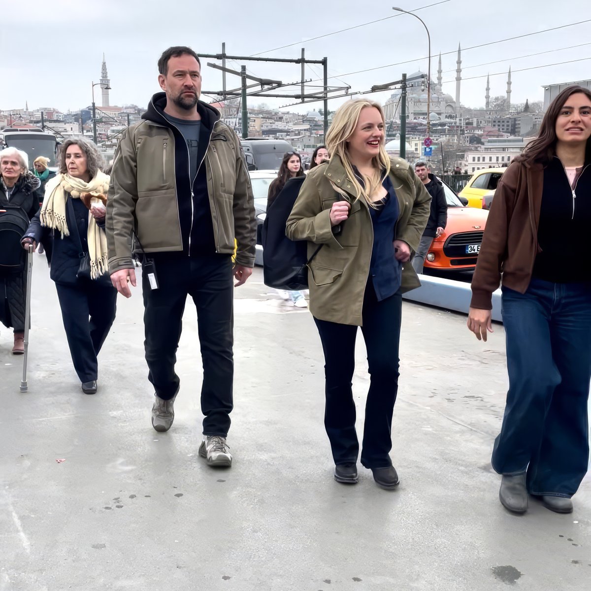Elisabeth Moss, arkada tarihi yarımada silueti, İstanbul'da bir köprüde Agun Security eşliğinde