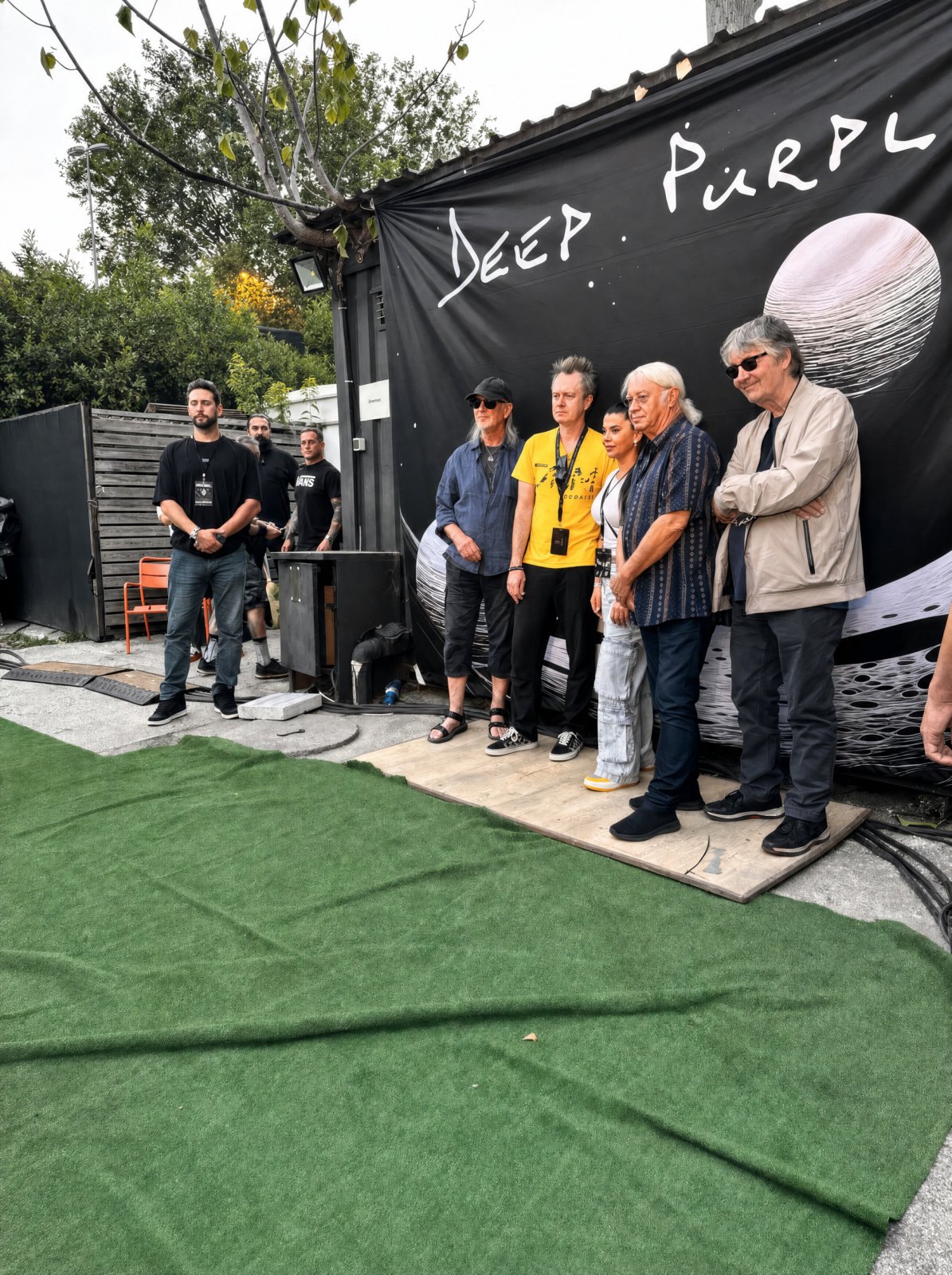 Deep Purple, sahne arkasında grup afişinin önünde, Agun Security ile