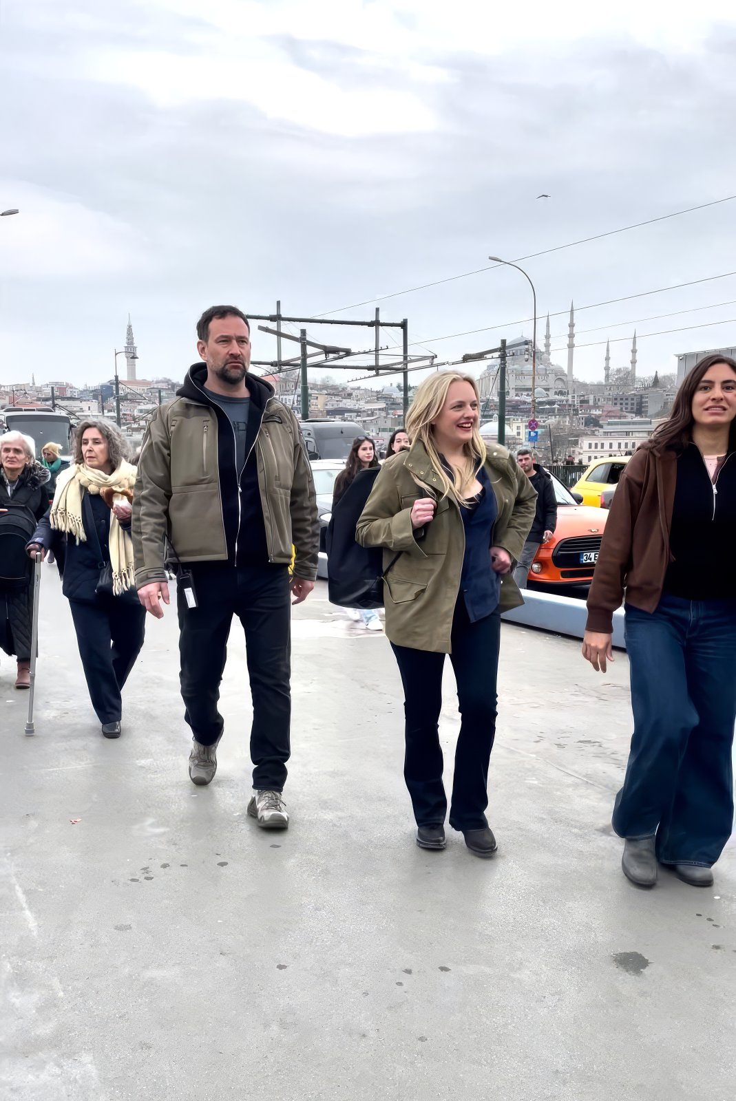 Elisabeth Moss, arkada tarihi yarımada silueti, İstanbul'da bir köprüde Agun Security eşliğinde