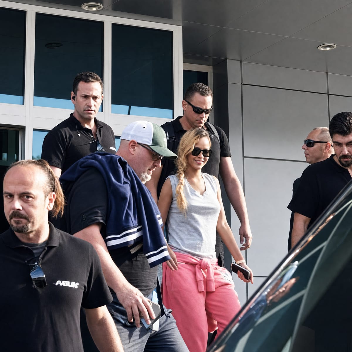 Rihanna, güneş gözlükleriyle bir binadan çıkarken, çevresinde Agun Security koruma ekibi